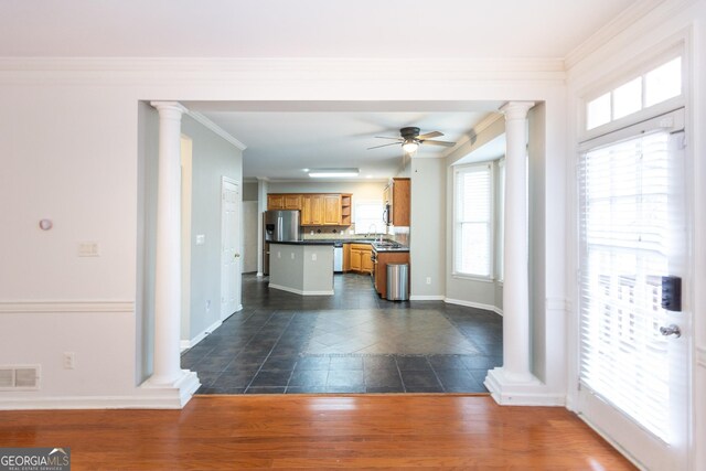 kitchen with ornamental molding, stainless steel appliances, ceiling fan, and a kitchen island