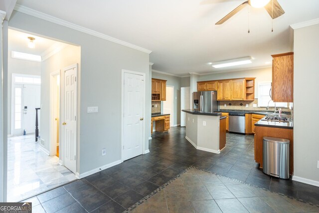 kitchen featuring sink, backsplash, ornamental molding, ceiling fan, and stainless steel appliances