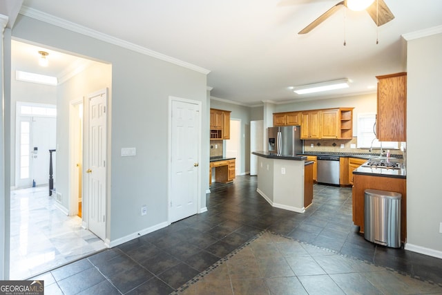 kitchen with open shelves, dark countertops, a center island, appliances with stainless steel finishes, and crown molding