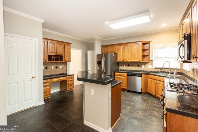 kitchen with sink, crown molding, appliances with stainless steel finishes, tasteful backsplash, and a kitchen island