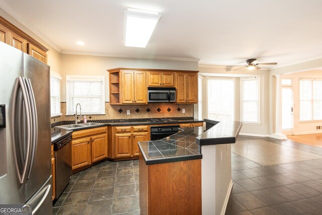 kitchen with tasteful backsplash, ornamental molding, a center island, and dark tile patterned floors