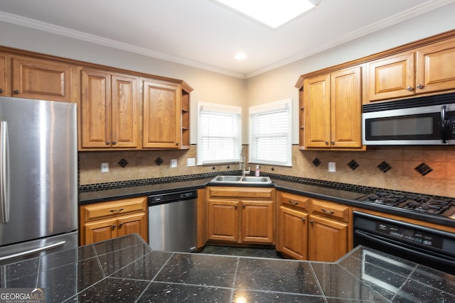 kitchen featuring a sink, decorative backsplash, appliances with stainless steel finishes, and ornamental molding