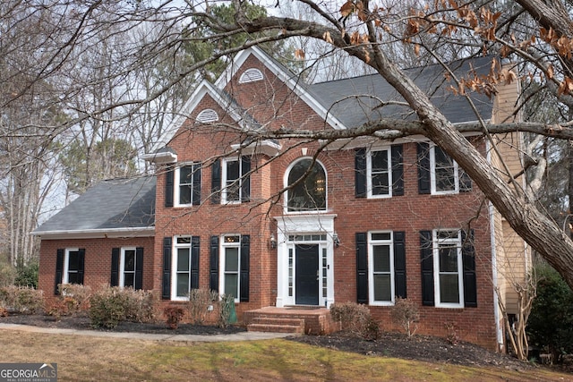 colonial-style house with brick siding