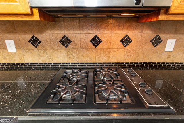 interior details with dark countertops, gas cooktop, and extractor fan