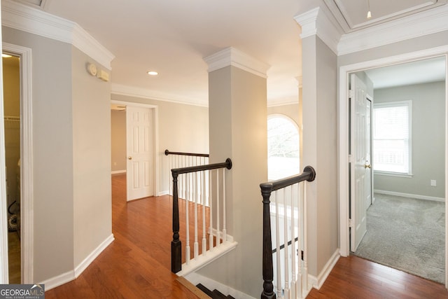 hall featuring wood finished floors, baseboards, attic access, crown molding, and an upstairs landing