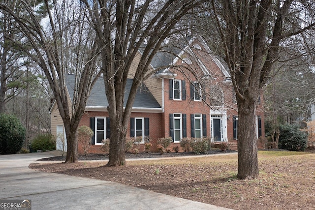 colonial home featuring brick siding