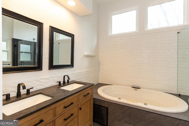 bathroom with vanity, tiled tub, and crown molding