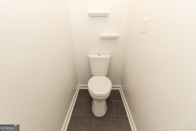 bathroom with tile patterned flooring, toilet, and baseboards