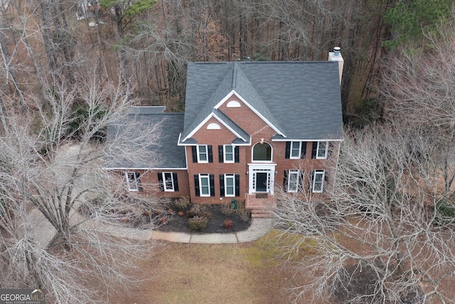 view of front of home with brick siding and a chimney