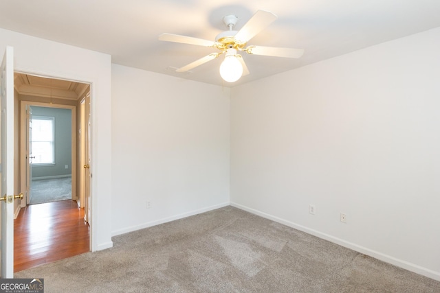 unfurnished room featuring attic access, baseboards, carpet floors, and ceiling fan