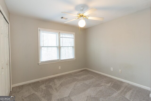 unfurnished bedroom featuring carpet, ceiling fan, and a closet