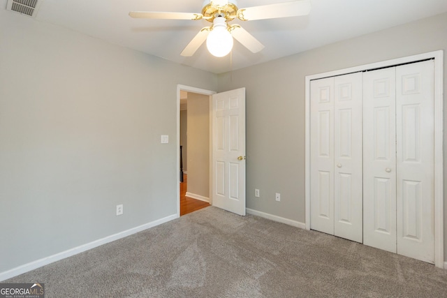 unfurnished bedroom with visible vents, a closet, carpet flooring, baseboards, and ceiling fan