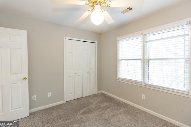 unfurnished bedroom featuring carpet flooring, baseboards, visible vents, and a closet