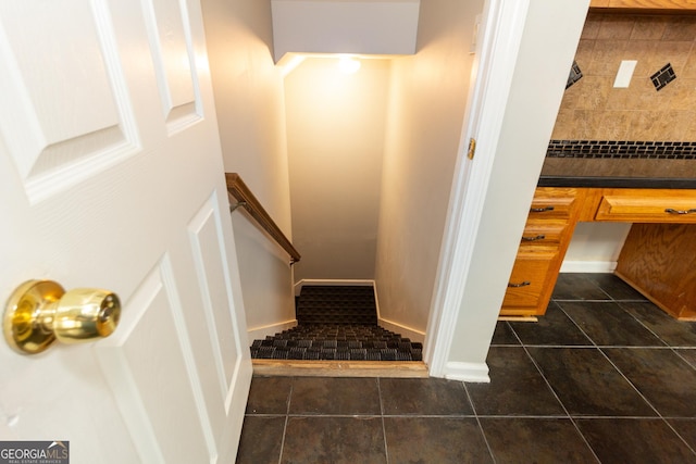 staircase featuring tile patterned flooring, baseboards, and built in desk