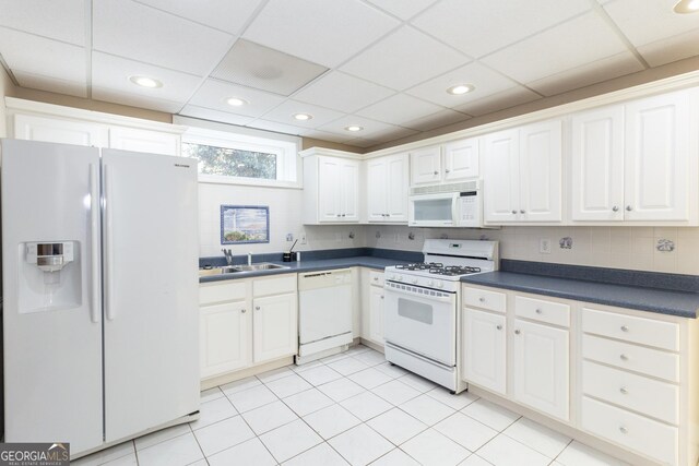 hall with a paneled ceiling, washer / clothes dryer, and light tile patterned floors