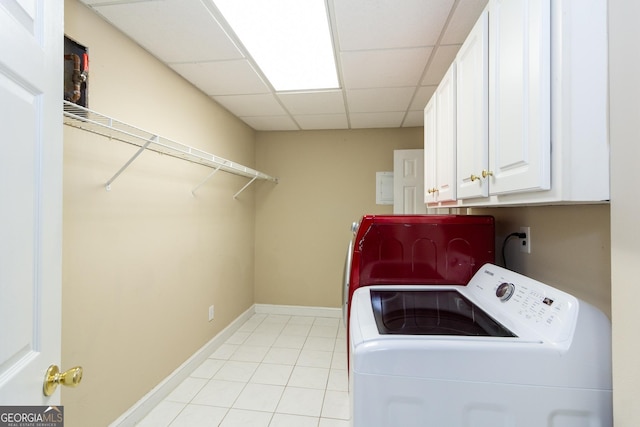 washroom with light tile patterned flooring, cabinet space, baseboards, and washer and clothes dryer