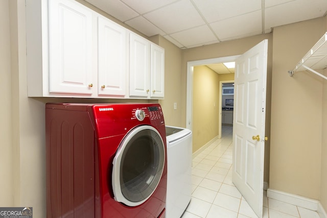 washroom featuring light tile patterned floors, cabinet space, independent washer and dryer, and baseboards