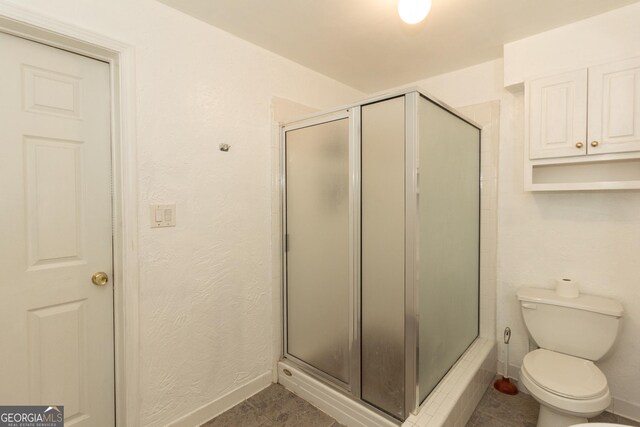 bathroom featuring a shower with door, sink, tile patterned floors, and toilet