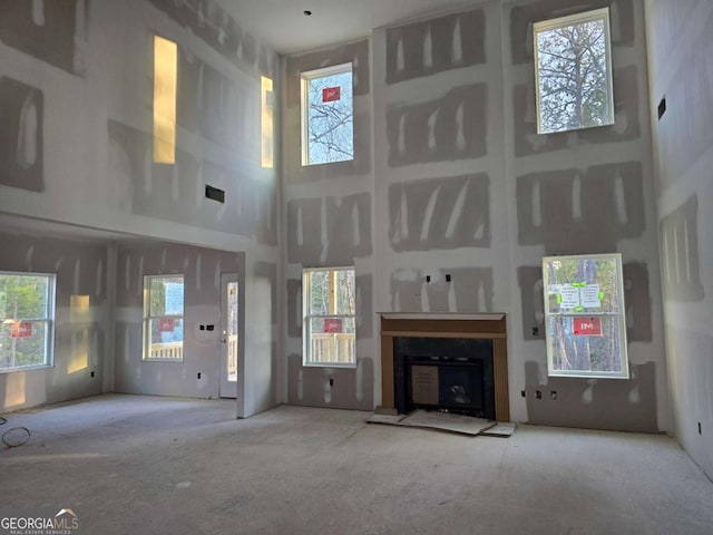 unfurnished living room with a towering ceiling and a wealth of natural light