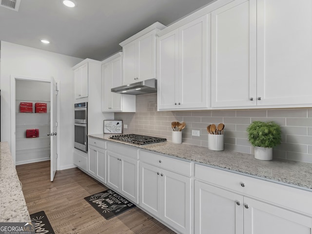 kitchen featuring stainless steel appliances, white cabinetry, light stone counters, and light hardwood / wood-style floors