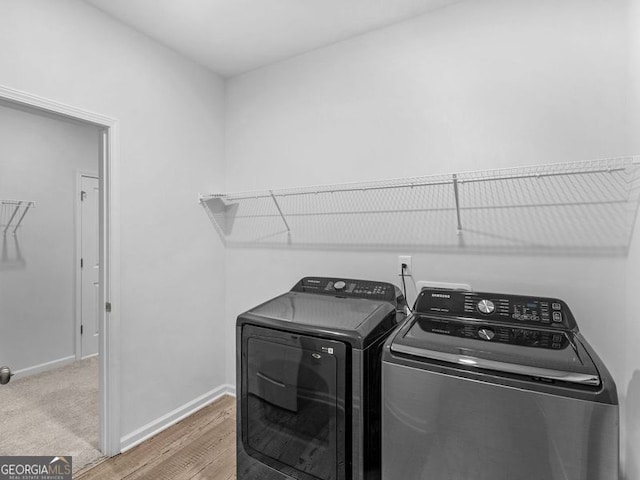 laundry room with hardwood / wood-style floors and washing machine and dryer