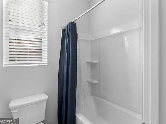 bathroom featuring shower / bath combo and toilet