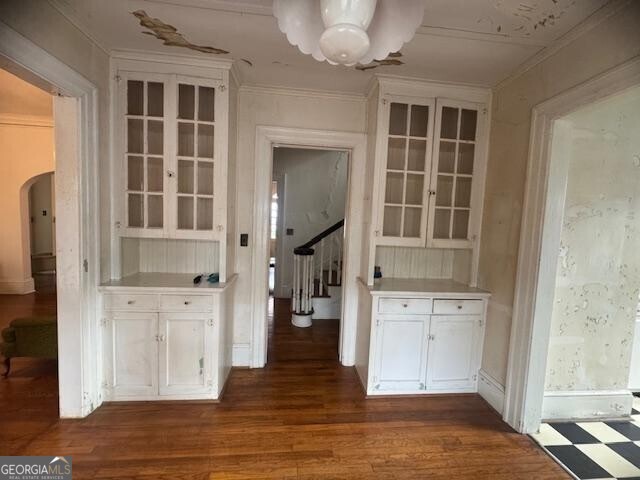 unfurnished dining area featuring ornamental molding and dark hardwood / wood-style floors