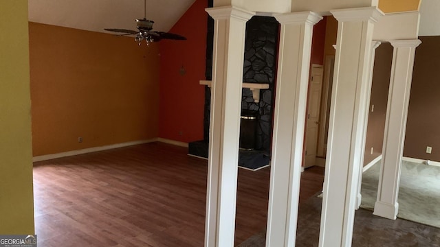 interior space featuring ornate columns, vaulted ceiling, and dark hardwood / wood-style flooring