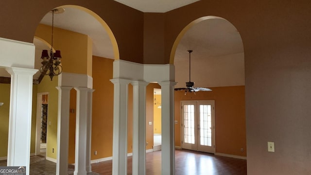 interior space featuring french doors, a towering ceiling, and ornate columns