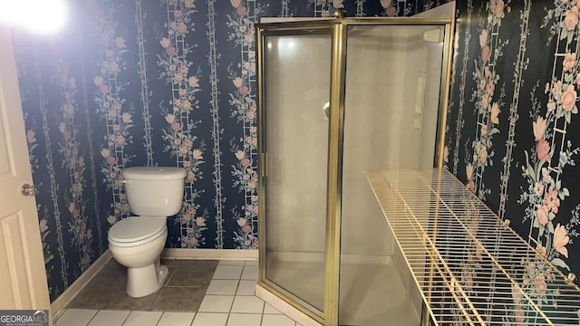 bathroom with a shower with shower door, tile patterned floors, and toilet