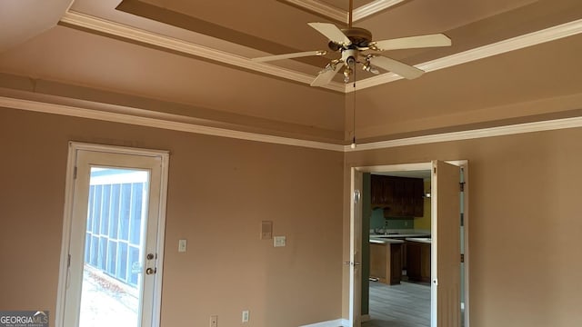 interior space featuring sink, crown molding, ceiling fan, vaulted ceiling, and a raised ceiling