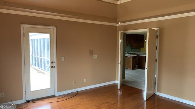 spare room with hardwood / wood-style flooring and crown molding