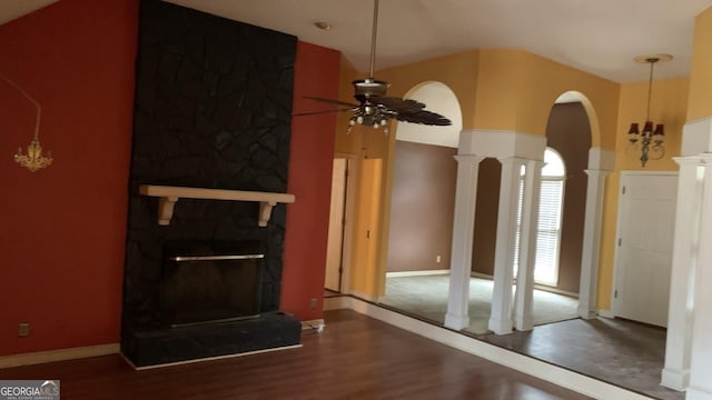 living room with hardwood / wood-style flooring, a large fireplace, ceiling fan, and ornate columns