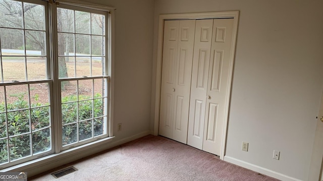 unfurnished bedroom featuring carpet floors and a closet