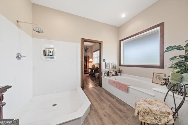 bathroom featuring hardwood / wood-style flooring and separate shower and tub