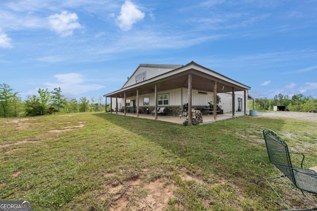 rear view of house with a patio and a lawn