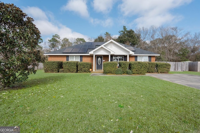 ranch-style home with a front lawn and solar panels