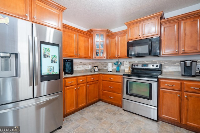 kitchen featuring stainless steel appliances, a textured ceiling, and backsplash