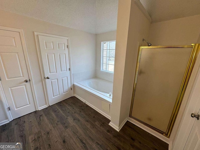 bathroom featuring hardwood / wood-style flooring, separate shower and tub, and a textured ceiling