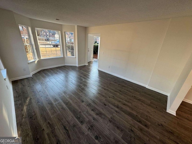 spare room featuring dark hardwood / wood-style floors and a textured ceiling