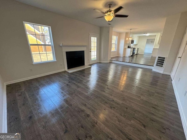 unfurnished living room with ceiling fan and dark hardwood / wood-style floors