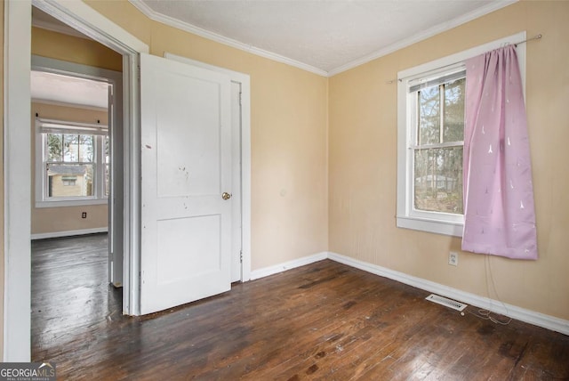 unfurnished room featuring ornamental molding, plenty of natural light, and dark wood-type flooring