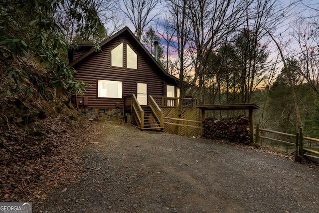 back house at dusk featuring a deck