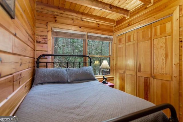 bedroom with beamed ceiling, wood ceiling, and wood walls