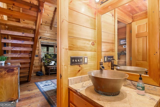 bathroom featuring wood ceiling, wooden walls, hardwood / wood-style flooring, and beamed ceiling