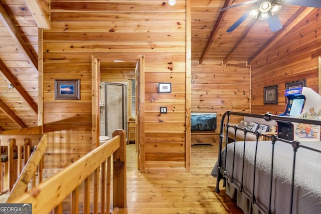 bedroom with wooden walls, lofted ceiling with beams, hardwood / wood-style floors, and wooden ceiling