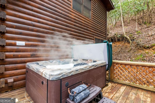 wooden terrace featuring a hot tub