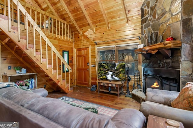 living room with wooden walls, a fireplace, wood-type flooring, vaulted ceiling with beams, and wooden ceiling