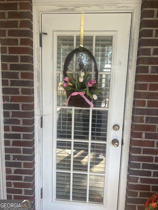 entrance to property featuring brick siding