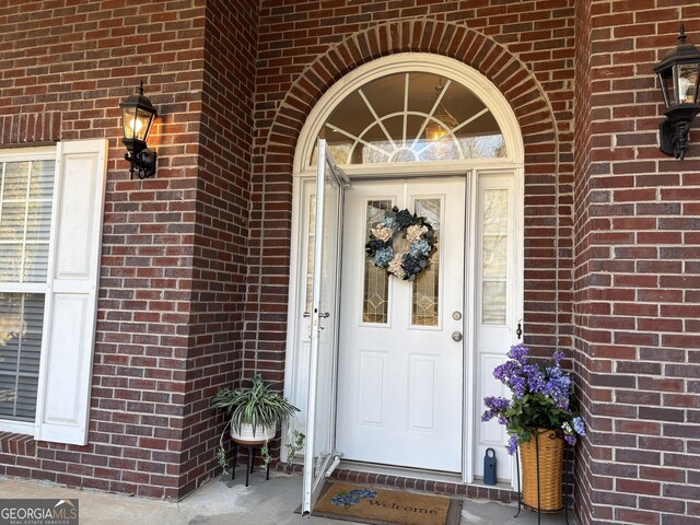 doorway to property with brick siding